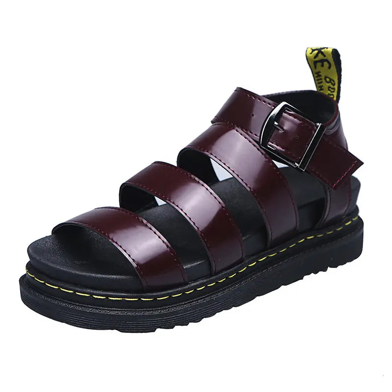 A pair of rich burgundy faux leather gladiator platform sandals with a chunky black sole and yellow stitching detail, shown from a front view.