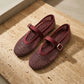 Galdyr Burgundy Wine rhinestone mesh Mary Jane flats with crystal-studded diamond netting and a suede-finish buckle strap, shown from a three-quarter angle on a textured beige surface.