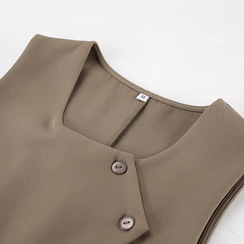 Close-up detail of a chic beige vest, featuring a square neckline, asymmetrical crossover front with two tonal buttons, and a visible size M label.