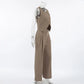 Women's chic beige vest and wide-leg trouser set viewed from the side, featuring an asymmetrical crossover vest and high-waisted pleated trousers. Elegant two-piece co-ord set.