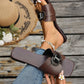 Chic chocolate brown square-toe flat slide sandals with an embellished buckle, shown on a woman's foot with distressed denim jeans and a straw hat.