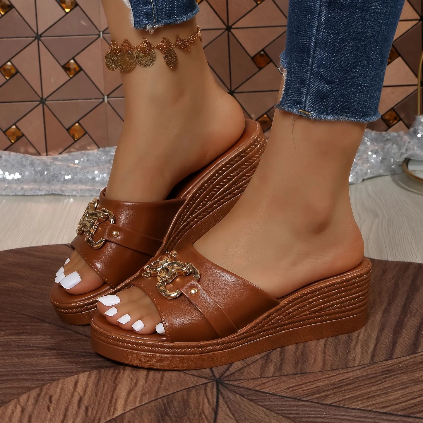 Warm cognac PU platform wedge sandals with a woven heel detail and ornate gold chain embellishment on the single toe strap, worn with denim jeans.