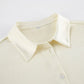 Close-up of the Tarkem crinkle pleat shirt in ivory buttercream, highlighting the classic pointed collar, tonal front button, and the distinctive textured fabric.