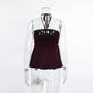 Back view of a dark plum ribbed halter crop top on a mannequin, showcasing thin adjustable straps tied at the nape of the neck.