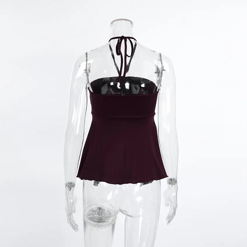 Back view of a dark plum ribbed halter crop top on a mannequin, showcasing thin adjustable straps tied at the nape of the neck.