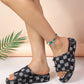 A woman's legs and feet wearing Zevon distressed denim checkerboard platform slides with frayed edges and a beaded anklet. The sandals are on a light peach background with a palm frond accent.