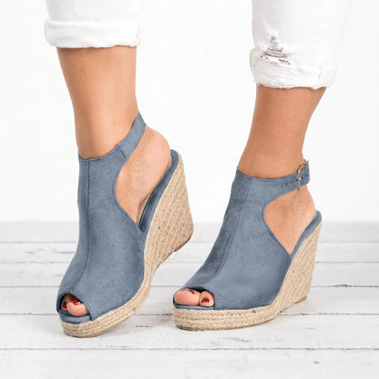Dusty blue espadrille wedge sandals with peep-toe front and adjustable ankle strap, worn by a model with distressed white jeans.