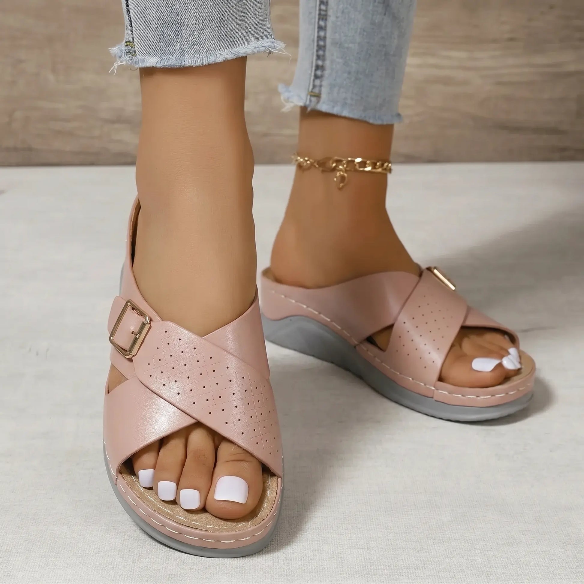 Dusty Rose faux leather platform slide sandals with micro-perforated straps and a gold-tone buckle, worn with denim jeans.