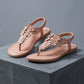 Blush apricot Elaraia bohemian flat t-strap sandals adorned with 3D sculpted flowers and clear rhinestones, featuring an elasticated slingback strap.