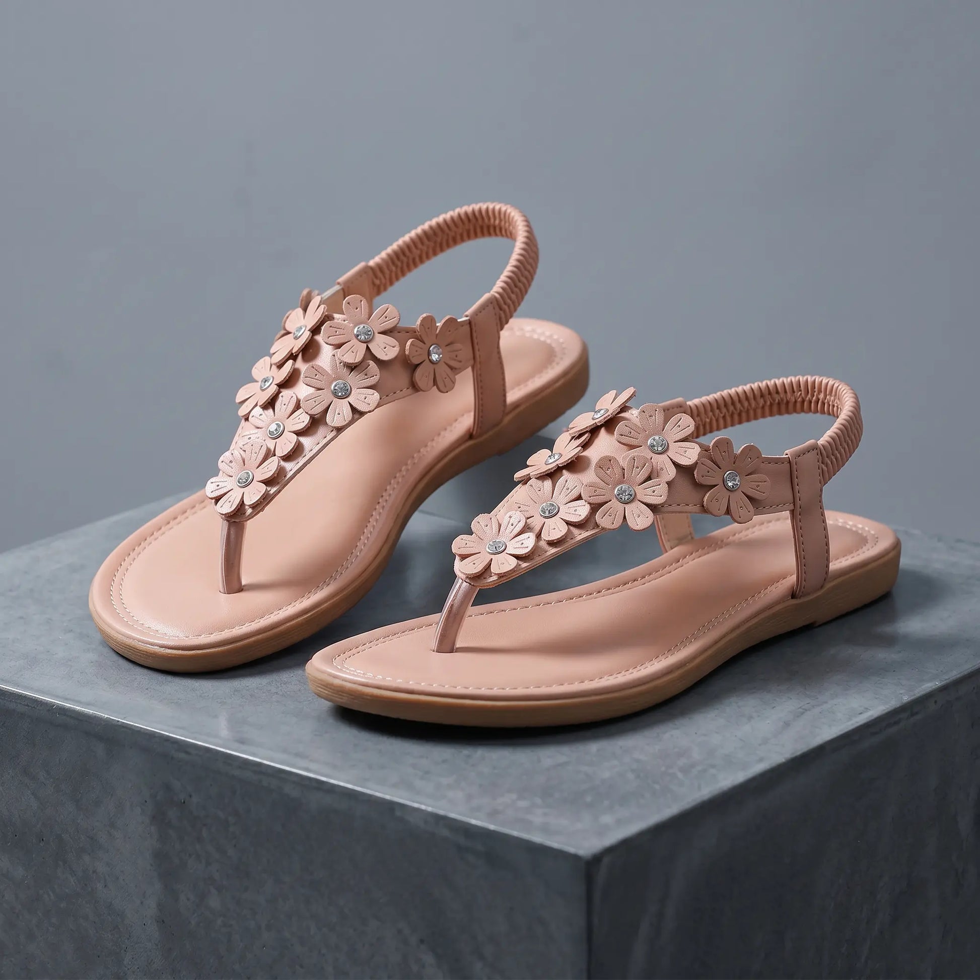 Blush apricot Elaraia bohemian flat t-strap sandals adorned with 3D sculpted flowers and clear rhinestones, featuring an elasticated slingback strap.