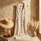 Elivora linen midi dress in beige with a button-down front, V-neck, and pockets, displayed in a summer-themed lifestyle setting.