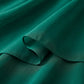 Close-up of the Kozumi A-Line midi dress's emerald green chiffon-blend fabric, showing its luxurious fluid drape, soft matte texture, and fine tonal stitching.