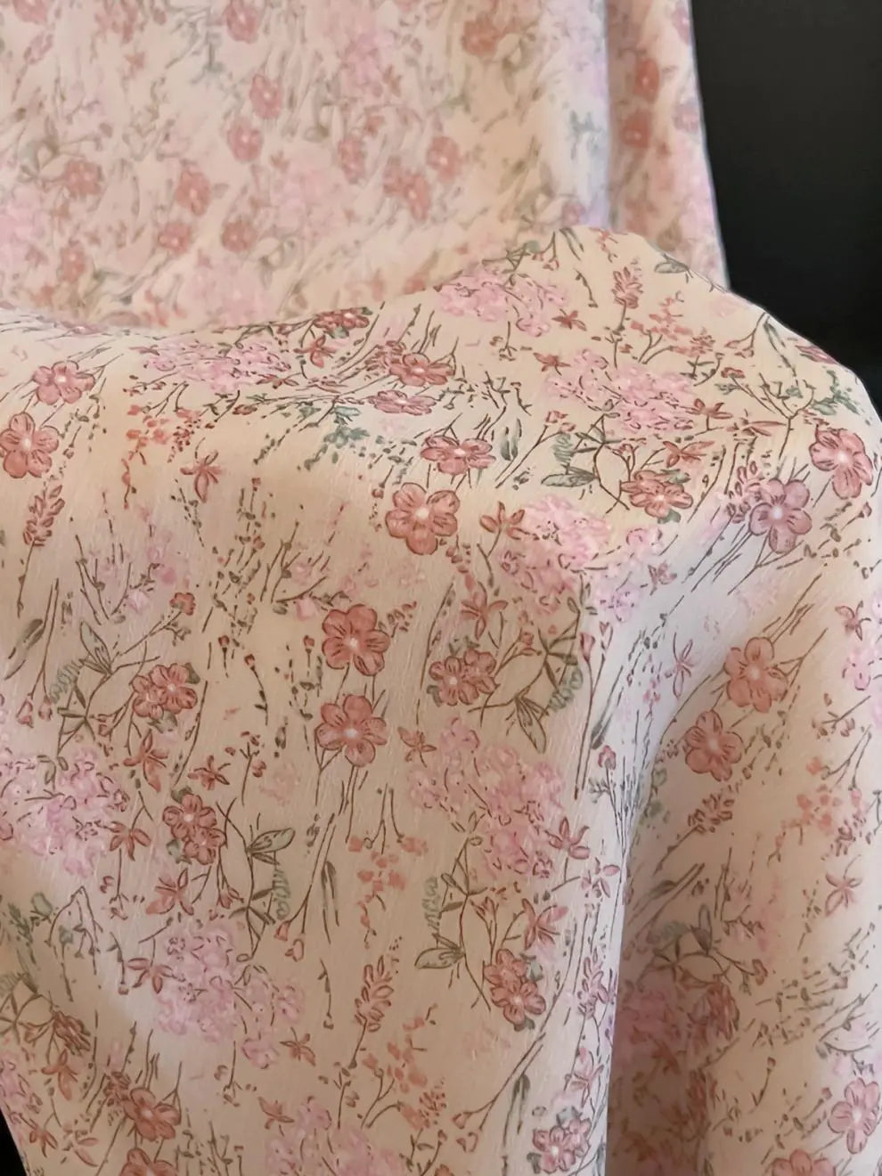 Close-up of Zhalis blush pink floral chiffon maxi skirt fabric, revealing delicate ditsy print with rose and sage tones.