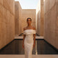 Female model wearing a high-polish gold liquid metal choker necklace and matching abstract earrings in a modern architectural setting.