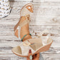 Shimmering gold metallic floral wedge sandals with elastic criss-cross straps and a gold-tone ring, shown on a foot against a light wooden background.