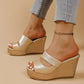 Gold metallic peep-toe platform wedge sandals with intersecting straps, textured snake-effect heel, shown on a model's feet styled with denim jeans.