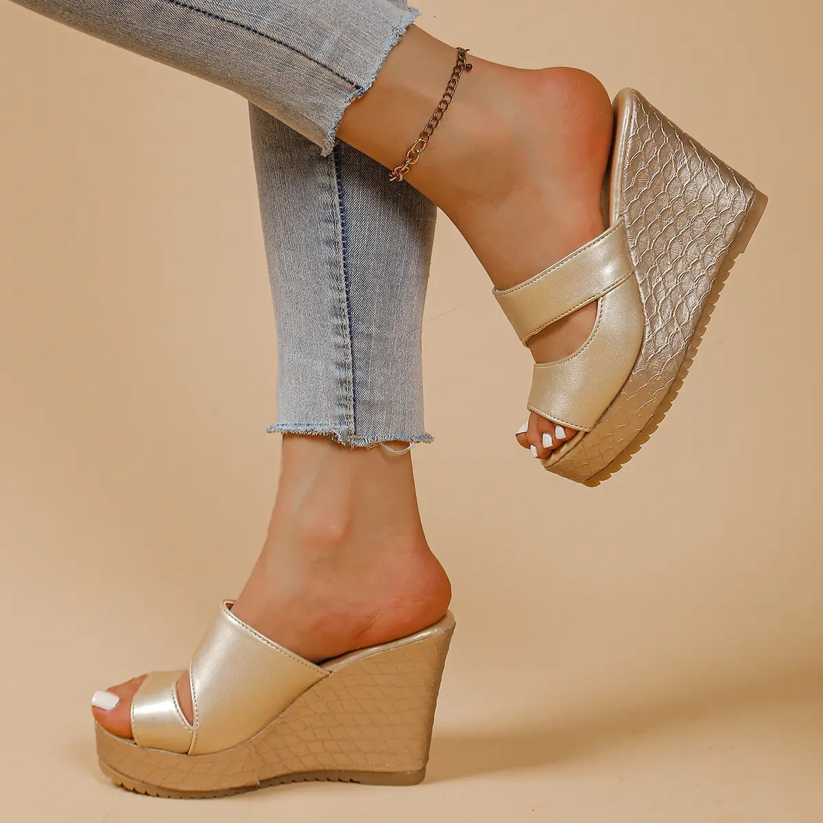 Champagne gold peep-toe mule wedge sandals with intersecting straps and a snake-textured 10cm heel and 4-5cm platform, styled with light-wash jeans.