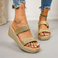 Women's shimmering gold woven strap platform wedge sandals shown on feet, styled with distressed denim jeans. These open-toe slip-on sandals feature a sculpted wedge heel and a subtle metallic sheen.