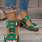 Green heeled platform slide sandals featuring gold-tone geometric hardware and white contrast stitching, worn with distressed jeans and a silver anklet.