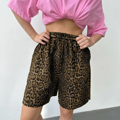 Gyzmar high-rise leopard print wide-leg shorts shown on a model from the waist down, featuring a classic brown and black animal print and elasticated waistband.