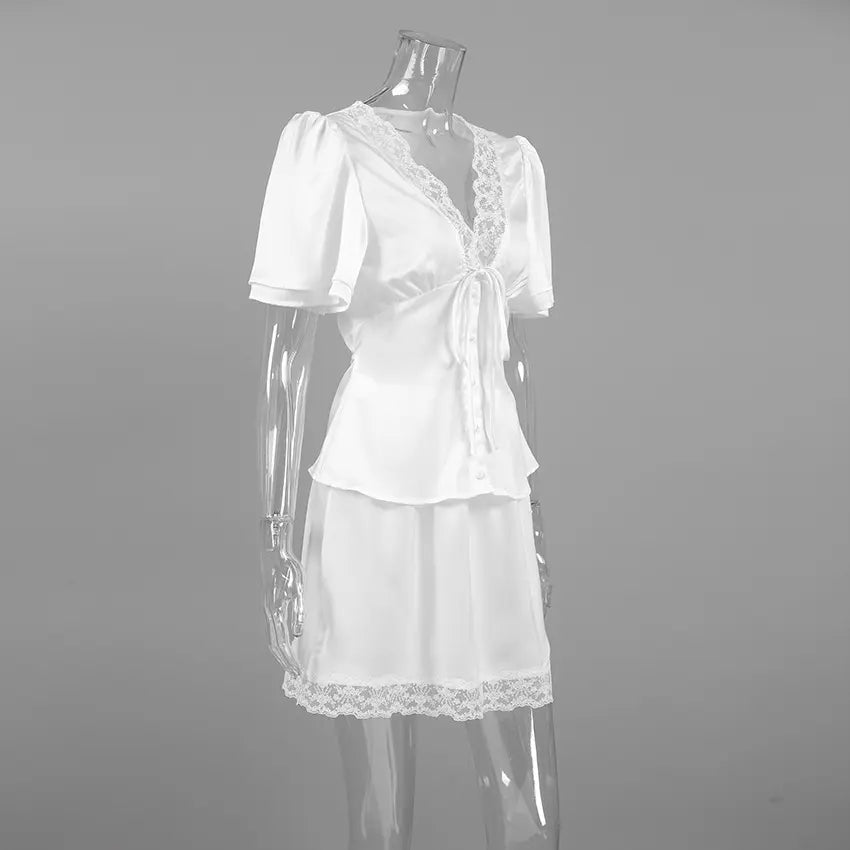 Side view of an ivory satin two-piece set featuring a V-neck blouse with delicate lace trim and puffed sleeves, paired with a lace-hem mini skirt, presented on a mannequin.