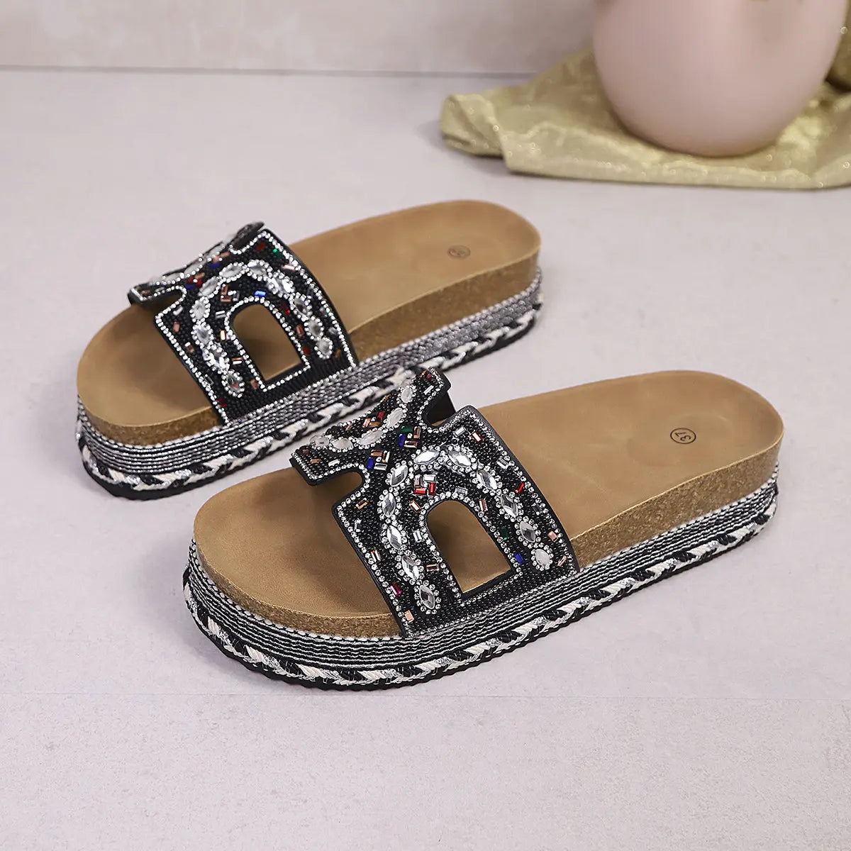 Jelani embellished platform slide sandals in black with U-shaped cutouts, featuring dazzling mixed bead and rhinestone detailing on the straps, cork footbed, and woven midsole.