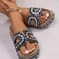Jelani embellished platform slide sandals worn on feet, featuring intricate bead and rhinestone U-shaped cutouts on a black strap, cork footbed, and woven platform sole.