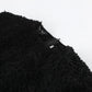 Close-up view of a black Kaelen dress, showcasing the intricate floral lace texture, plush faux fur material, and a visible zipper with size label XS.