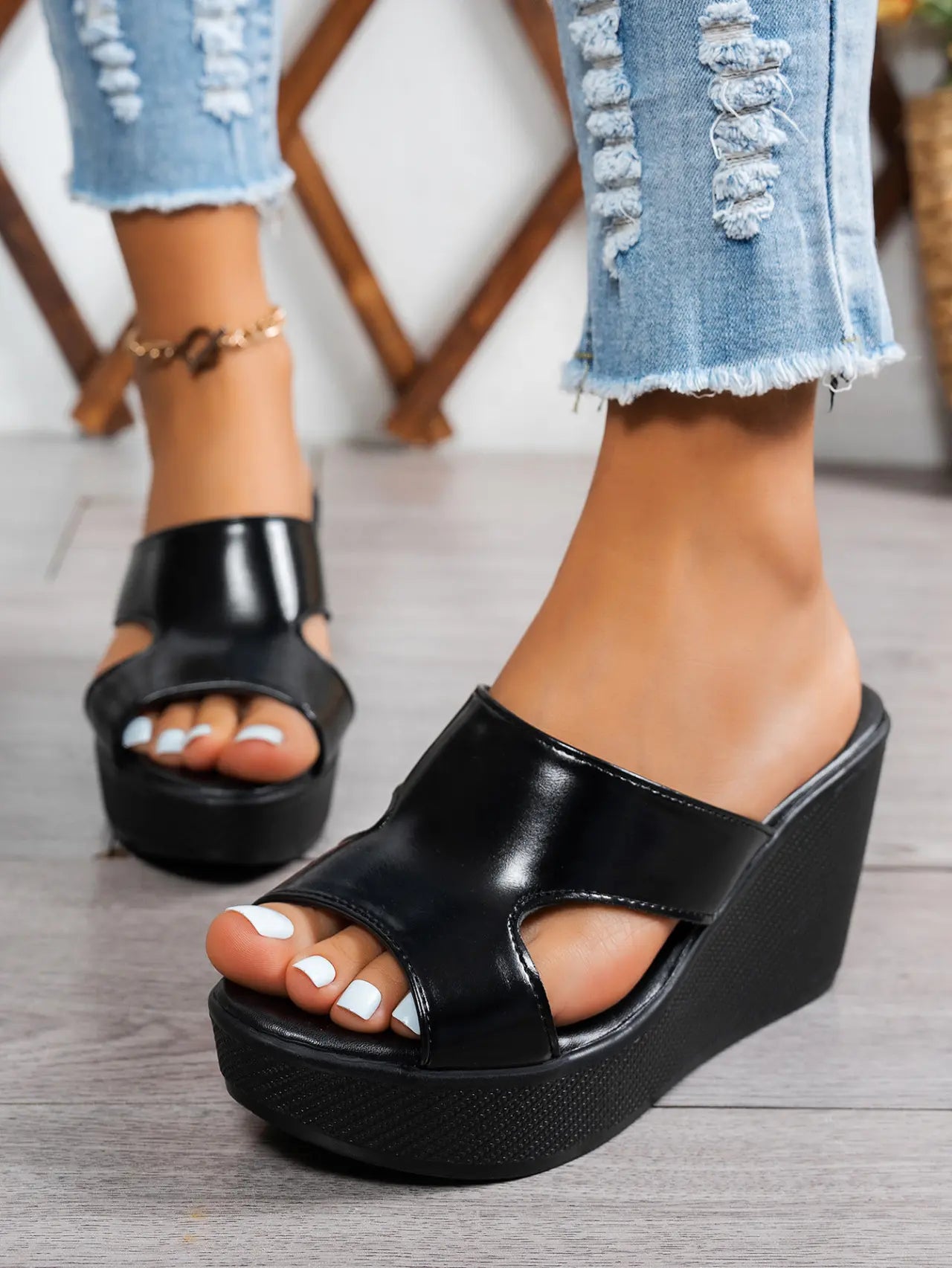 Black Kaelen elegant wedge sandals with peep-toe design and single PU strap, styled with ripped denim jeans on a model's feet.