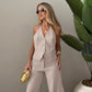 Model wears a chic, neutral beige Kaelen wide-leg ensemble featuring a V-neck halter vest and flowing palazzo trousers, styled with modern accessories.