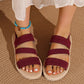 Deep Garnet Kaelen flat sandals with woven elastic straps and braided sole trim, shown on feet with a turquoise anklet.