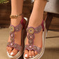 Dazzling embellished wedge sandals in metallic rose gold, featuring intricate circular rhinestone and bead designs on the vamp strap and a chic woven espadrille-style wedge heel, worn by a model with ripped jeans.