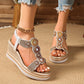 Kaelen embellished wedge sandals in rose-gold and gold metallic finishes, featuring intricate circular rhinestone and bead patterns, woven espadrille wedge sole, shown worn with denim jeans.