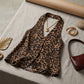 Kaelen leopard print halter top laid flat with gold heart necklace, bangles, and burgundy handbag on a textured neutral background.