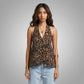 Front view of a woman wearing a Kaelen leopard print halter neck top with a deep V-neck and subtle front buttons, paired with light blue jeans.