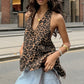 Kaelen leopard print halter top with deep V-neck and open back, worn by a model on a city street with denim jeans.