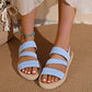 Light blue Kaelen woven strap flat sandals with elasticated straps and a braided sole trim, worn by a woman with a turquoise anklet.