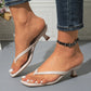 Elegant off-white heeled thong sandals with a square toe and sculptural block heel, worn by a model with a black beaded anklet and denim jeans.