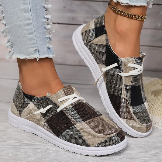 Kaelen plaid canvas slip-on loafers with white laces and white soles, worn with distressed denim jeans and a gold anklet, offering a casual everyday style.