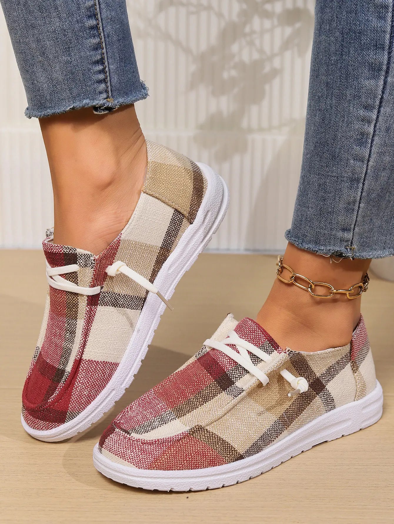 Kaelen women's plaid canvas slip-on loafers with white laces and white rubber soles, worn with denim jeans and a gold ankle bracelet.