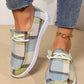 Lifestyle shot of Kaelen comfortable canvas loafers worn by a model with cropped jeans, showcasing the earthy green, blue, and beige plaid pattern and white rubber sole.
