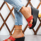 Kaelen red peep-toe wedge sandals styled with distressed denim jeans, showcasing the elegant single strap and stable platform heel on a woman's foot with an ankle bracelet.