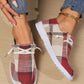 Kaelen women's plaid canvas slip-on loafers in warm red plaid, worn with blue jeans and featuring white decorative laces and a white rubber sole.