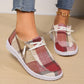 Close-up lifestyle shot of Kaelen plaid canvas loafers worn with blue jeans, showcasing the red, beige, and brown plaid pattern and white laces against a warm wooden floor.