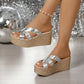 Kaelen women's silver cracked metallic criss-cross strap espadrille wedge sandals shown from a three-quarter angle, styled with a subtle anklet on a glittering party-themed background.
