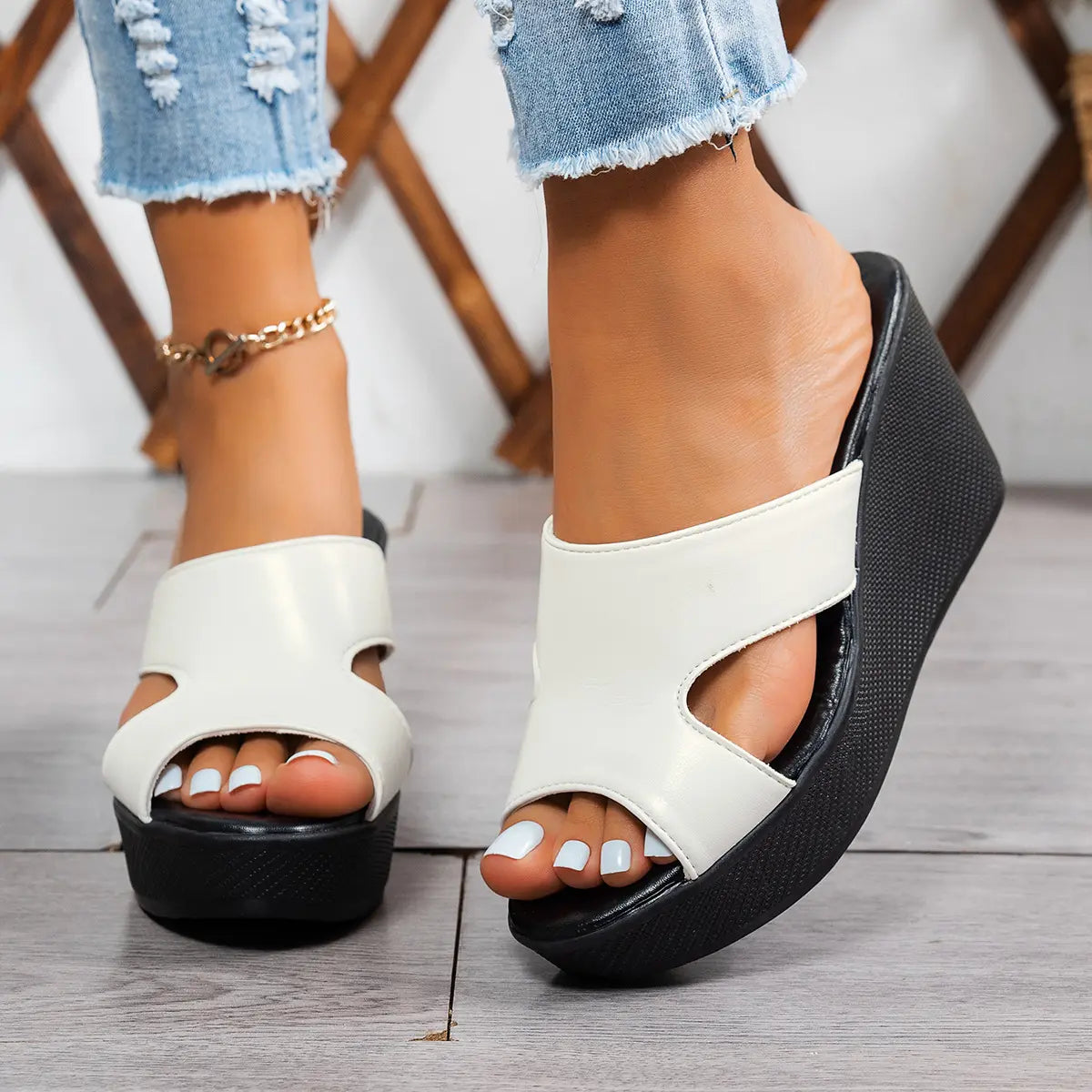Close-up of Kaelen elegant white peep-toe wedge platform sandals worn by a woman with ripped denim jeans, showcasing the comfortable 6-8cm heel and single PU strap on a wooden floor.