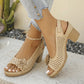Beige Kaelia chunky heel sandals featuring a peep-toe, floral embellishment, and perforated upper, shown on a model's feet with denim jeans against a neutral lifestyle background.