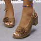 Brown Kaelia chunky heel sandals featuring a floral embellishment, open peep toe, perforated design, and an adjustable ankle strap worn on a model's feet.