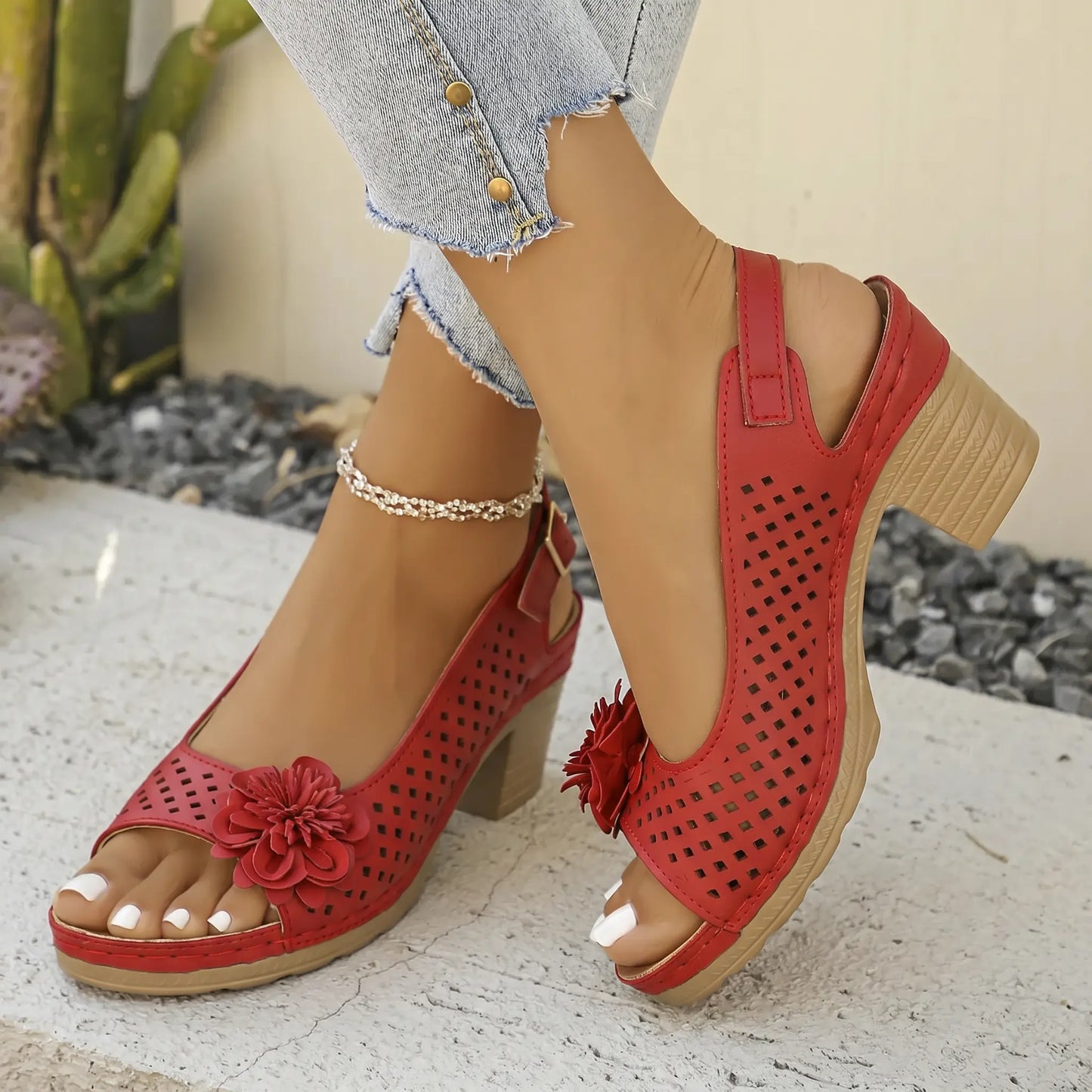 Red Kaelia chunky heel sandals with floral embellishment and square perforation, shown on a model's feet with a slingback strap and peep toe.