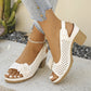 White Kaelia peep-toe chunky heel sandals with floral embellishment and perforated upper, shown on a woman's feet with light-wash jeans and an anklet.